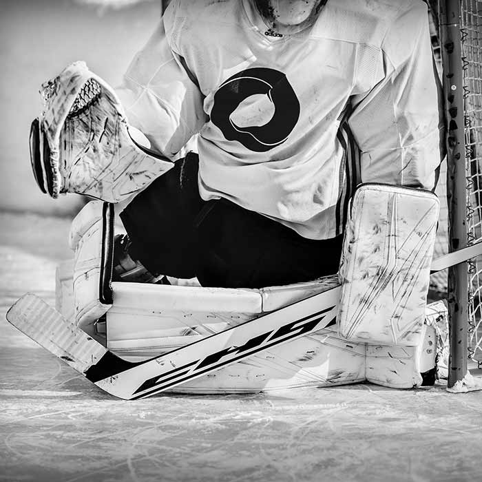 Goalie blocking a shot holding a Custom Hockey Stick.