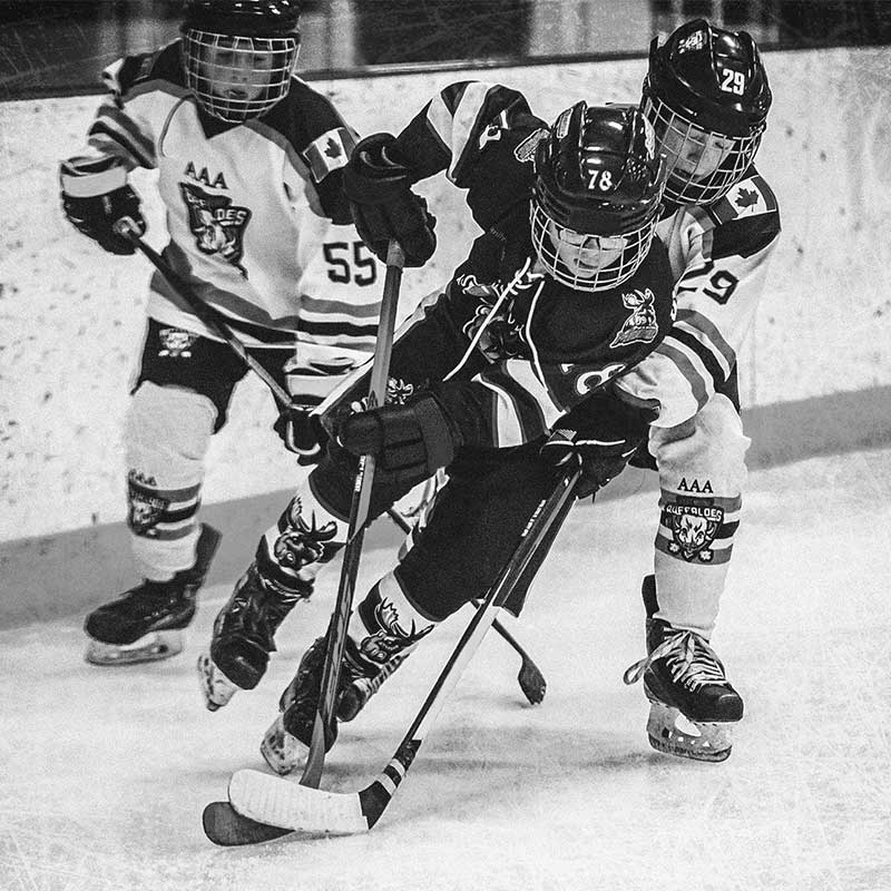 Hockey players battling it out in a corner during a competitive match.