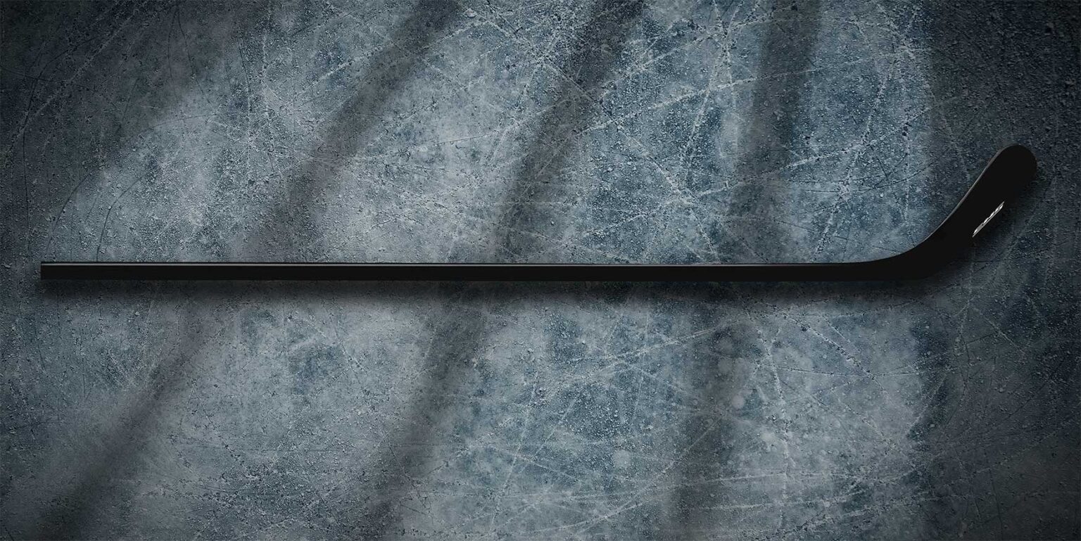 UD carbon fiber hockey stick sitting on a frozen lake.
