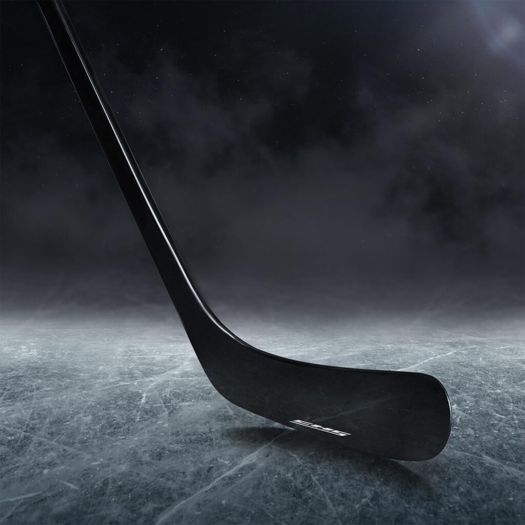 UD carbon fiber hockey stick sitting on a frozen lake.